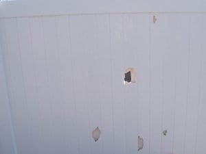 Holes in a damaged PVC vinyl fence