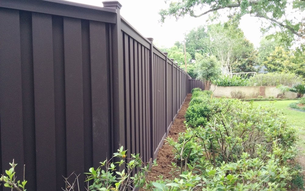 A Trex composite fence in Lafayette, Louisiana separating a homeowner property from a school