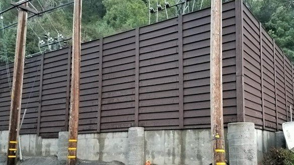A tall Trex Horizons horizontal fence built around a substation.
