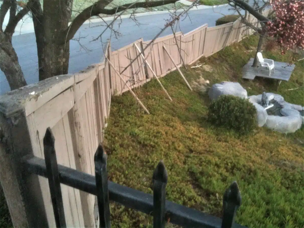 A picture of a dilapidated wood fence before upgrading it with a Trex Fence