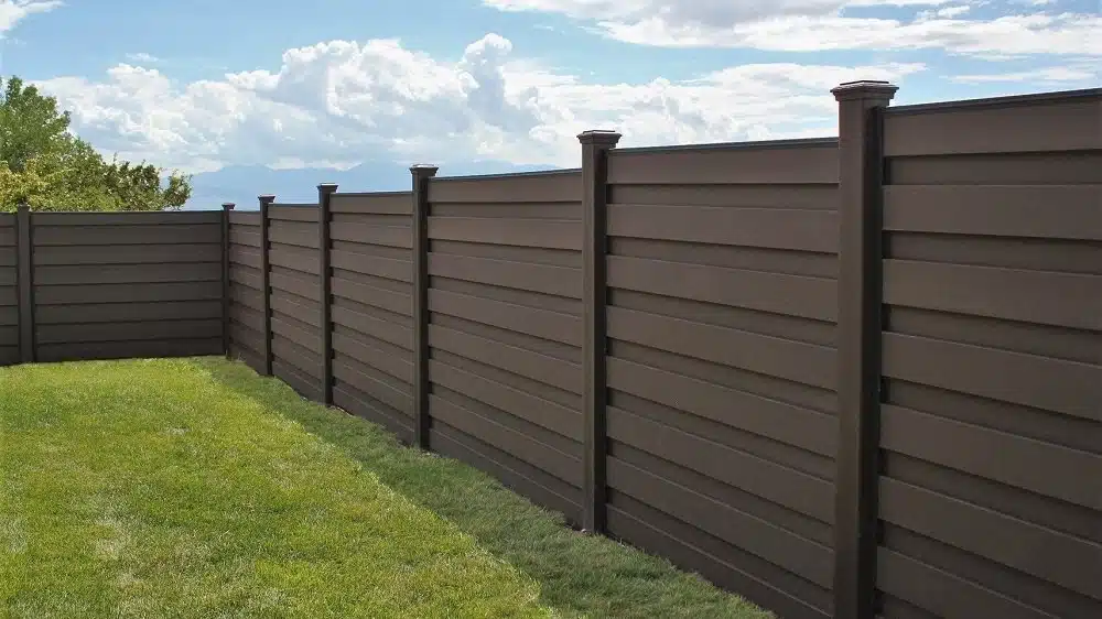 A Trex horizontal fence stepping with sloping ground down a hill