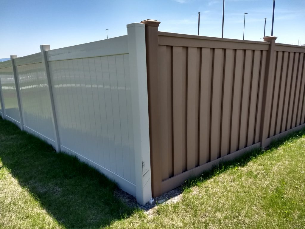 A Trex fence next to a PVC vinyl fence. The reflectivity of the plastic PVC vinyl contrasts sharply with the natural, matte surface of Trex.