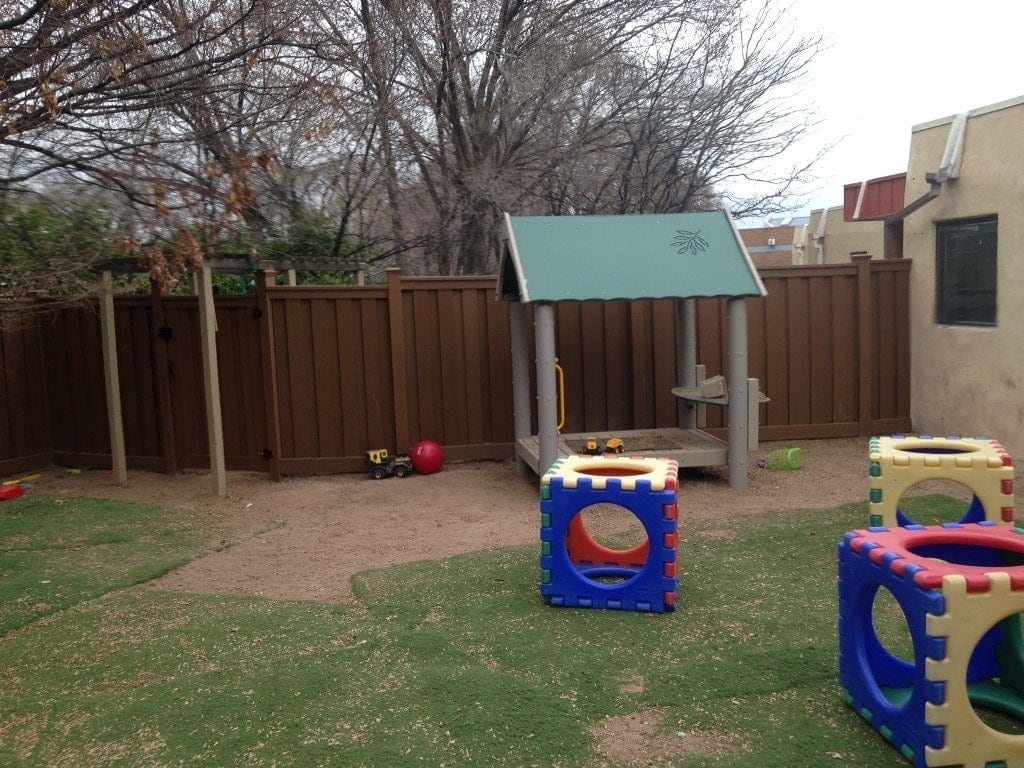 A small payground in front of a Trex Fence at La Comunidad de los Ninos school in Santa Fe, NM.