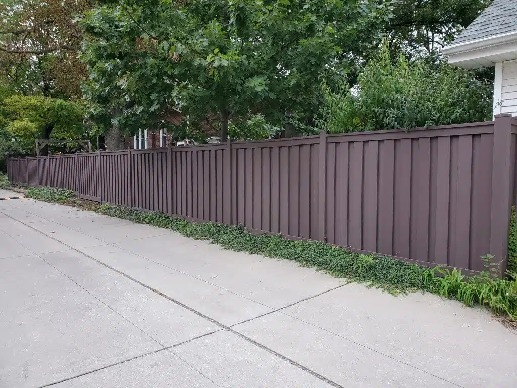A Woodland Brown Trex Fence along a paved alley in Chicago