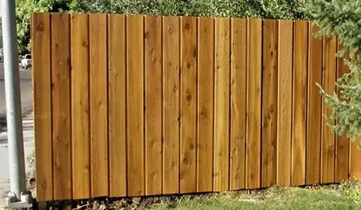 A wood fence with pickets overlapping to create a board-on-board look.
